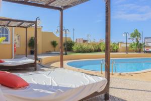 a pool with two beds in front of a resort at Quinta Nova Vale Del Rey in Carvoeiro