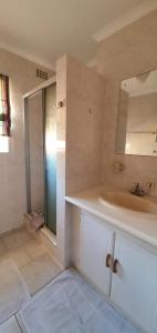 ein Bad mit einem Waschbecken und einem Spiegel in der Unterkunft Hinterheim in Lambertʼs Bay