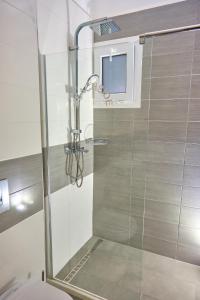 a shower with a glass door in a bathroom at Beachside Bungalows Acharavi Corfu in Acharavi