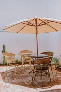 a table and chairs with an umbrella on a patio at Pousada Velas do Forte in Cabo Frio
