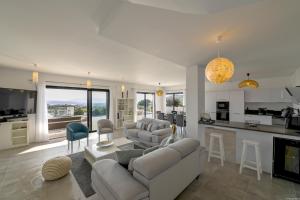 a living room with couches and a kitchen and a living room at Villa neuve et luxueuse vue mer proche Portovecchio in Zonza