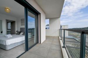 a bedroom with a bed on a balcony at Villa neuve et luxueuse vue mer proche Portovecchio in Zonza +35 photos