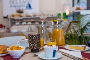 a table topped with plates of food and orange juice at Hotel Chalet del Lago in Avigliana