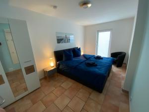 1 dormitorio con cama azul y espejo en FeWo-Airport, en Blankenfelde