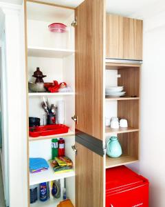 a kitchen pantry with a wooden door and shelves at Apartamentos com vista para o Mar - Mirante do Marinas in Angra dos Reis