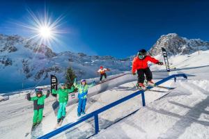 un grupo de personas esquiando en un carril en la nieve en Au 6ème ciel Tignes 2100m - Vue Lac & Montagnes - Proche pistes - 2 adultes et 2 enfants, en Tignes