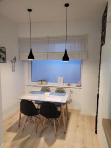 ein Esszimmer mit einem Tisch, Stühlen und einem Fenster in der Unterkunft Apartamenty Cieplicka 20 in Jelenia Góra