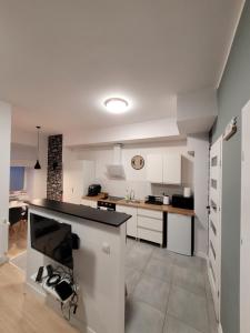 eine Küche mit weißen Schränken und einer schwarzen Arbeitsplatte in der Unterkunft Apartamenty Cieplicka 20 in Jelenia Góra