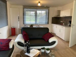 a living room with a couch and a kitchen at Vakantiehuis Ervedriestreek in Den Ham