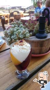 a drink in a glass sitting on a table at Raganas Ķēķis Hotel in Ragana