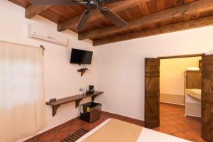 Hotel 1697 Loreto في لوريتو: غرفة معيشة مع مروحة سقف وتلفزيون