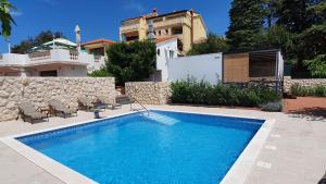 a swimming pool in front of a house at Premium Appartments Suha Punta in Rab