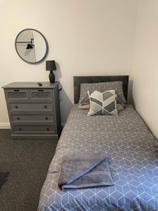a bedroom with a bed with a dresser and a mirror at Bedlington apartment in Bedlington