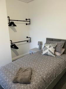 a bedroom with a bed with clothes racks on the wall at Bedlington apartment in Bedlington