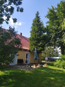 uma casa com um guarda-chuva no quintal em Domek na wzgórzu Blanki em Lidzbark Warmiński