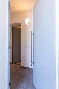 een hal met een schuifdeur en een open deur bij Appartamento Campagnola con giardino privato e due camere da letto in Riva del Garda