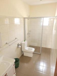 y baño con aseo, ducha y lavamanos. en Appartement chic au quartier Omnisport en Yaundé