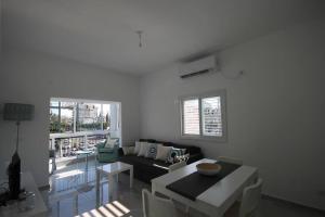 uma sala de estar com um sofá e uma mesa em Appartement cosy entre mer et ville avec parking gratuit a proximite em Netanya