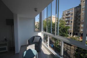 a living room with a chair and a large window at Appartement cosy entre mer et ville avec parking gratuit a proximite in Netanya