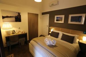 a hotel room with a bed with a desk and a bed sidx sidx sidx sidx at Mavà in Catania +19 photos