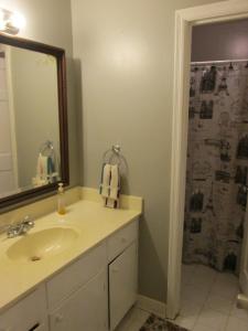 y baño con lavabo y ducha con espejo. en Cayce Charm Minutes to Downtown Columbia, en Cayce