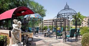 um pátio com mesas, cadeiras e gazebos em Hotel The Corner Roma em Roma