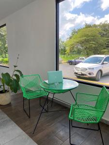 eine Terrasse mit einem Tisch, Stühlen und einem Laptop in der Unterkunft Hotel La Isla in Cunduacán