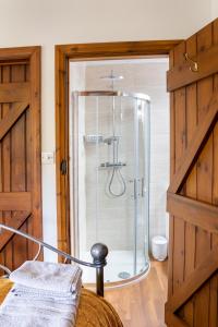 eine Dusche mit Glastür in einem Zimmer in der Unterkunft Granary Cottage - Luxury Barn Conversion in Weston Subedge