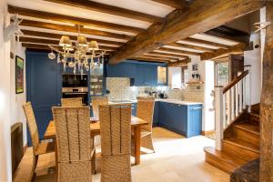 a dining room with blue walls and a wooden table and chairs at Granary Cottage Luxury Barn Conversion in Weston Subedge