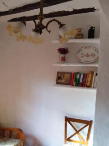 Habitación con lámpara de araña y estanterías con libros. en Casa de Amparo y José Manuel, en Pavías