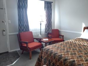 una camera d'albergo con due sedie e un letto e una finestra di The Lodge at West River a Newfane