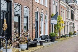 a row of buildings with benches and plants on a street at Stadslogement Het Keerpunt Dokkum in Dokkum