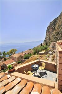 een terras met een tafel en stoelen bij Izambo Guest Houses in Monemvasia