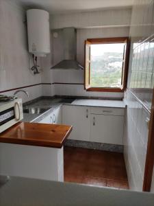 Una pequeña cocina con fregadero y ventana. en La Rueda Apartamentos Rurales, en Chulilla