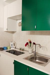 ナポリにあるBianca Napoli Suiteのキッチン(緑と白のキャビネット、シンク付)