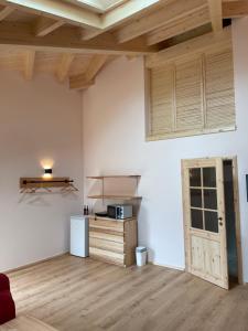 a room with white walls and wooden ceilings and a kitchen at Carolinger Hüttendorf in Weyer