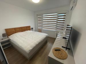 a bedroom with a bed and a table and a window at DeTY's Apartment in Burgas City