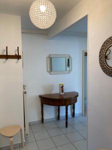 a small table in a room with a mirror at TANGO appartement de charme calme lumineux 75m2 6 personnes in Mulhouse