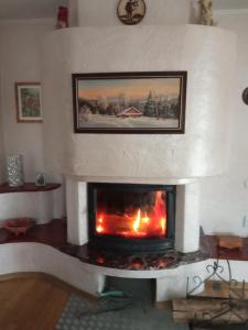 una chimenea con chimenea en la sala de estar en Затишок, en Yaremche