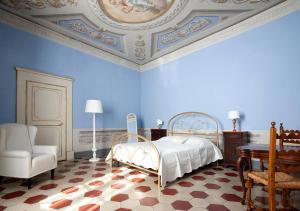 a blue bedroom with a bed and a chair at Almadelena Guest House in Pisa