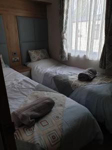 Ein Bett oder Betten in einem Zimmer der Unterkunft Luxury Tattersall Lakes Hot Tub Staycation 6 Berth Luxury Caravan