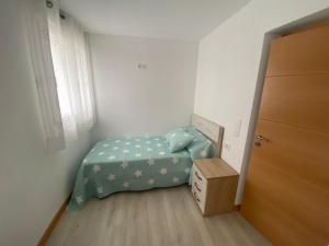 een kleine slaapkamer met een bed en een houten vloer bij Vivienda San José in Teruel