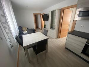 ein kleines Wohnzimmer mit einem Tisch und einer Küche in der Unterkunft Vivienda San José in Teruel