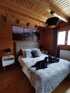 1 Schlafzimmer mit 2 Betten in einem Zimmer mit Holzwänden in der Unterkunft Chalet chaleureux au cœur du massif du haut Jura in Mignovillard