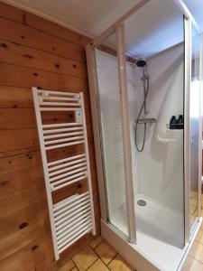 a shower in a bathroom with wooden walls at Chalet chaleureux au cœur du massif du haut Jura in Mignovillard