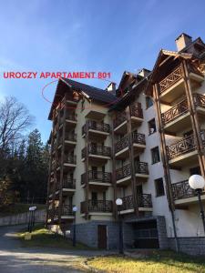 un edificio de apartamentos con un cartel en él en Apartament Urocza przy Wyciągu SKI Arena en Szklarska Poręba