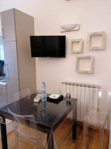 een eetkamer met een tafel en een televisie aan de muur bij Casa Al Poggetto in Florence