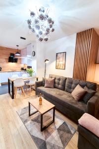 ein Wohnzimmer mit einem Sofa und einem Tisch in der Unterkunft LAGUNA Apartament Polanica Residence 39 in Polanica-Zdrój