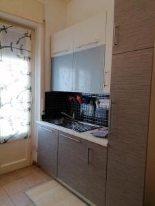a kitchen with white cabinets and a sink at Poggetto home in Florence
