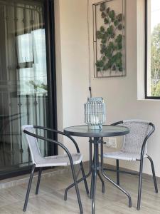 a glass table and two chairs in a room at Ruebys Apartment 202 in Dullstroom